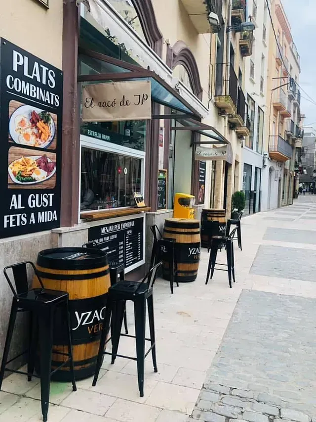 Una fila de barriles y mesas afuera de un restaurante