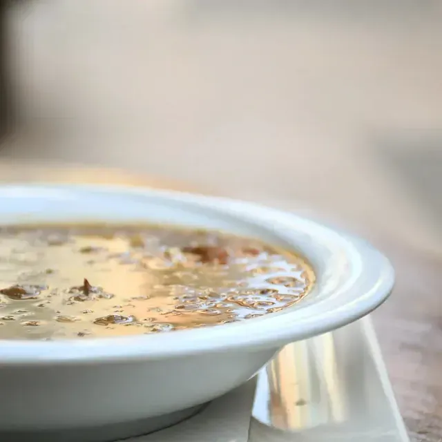 Un primer plano de un tazón de sopa sobre una mesa.