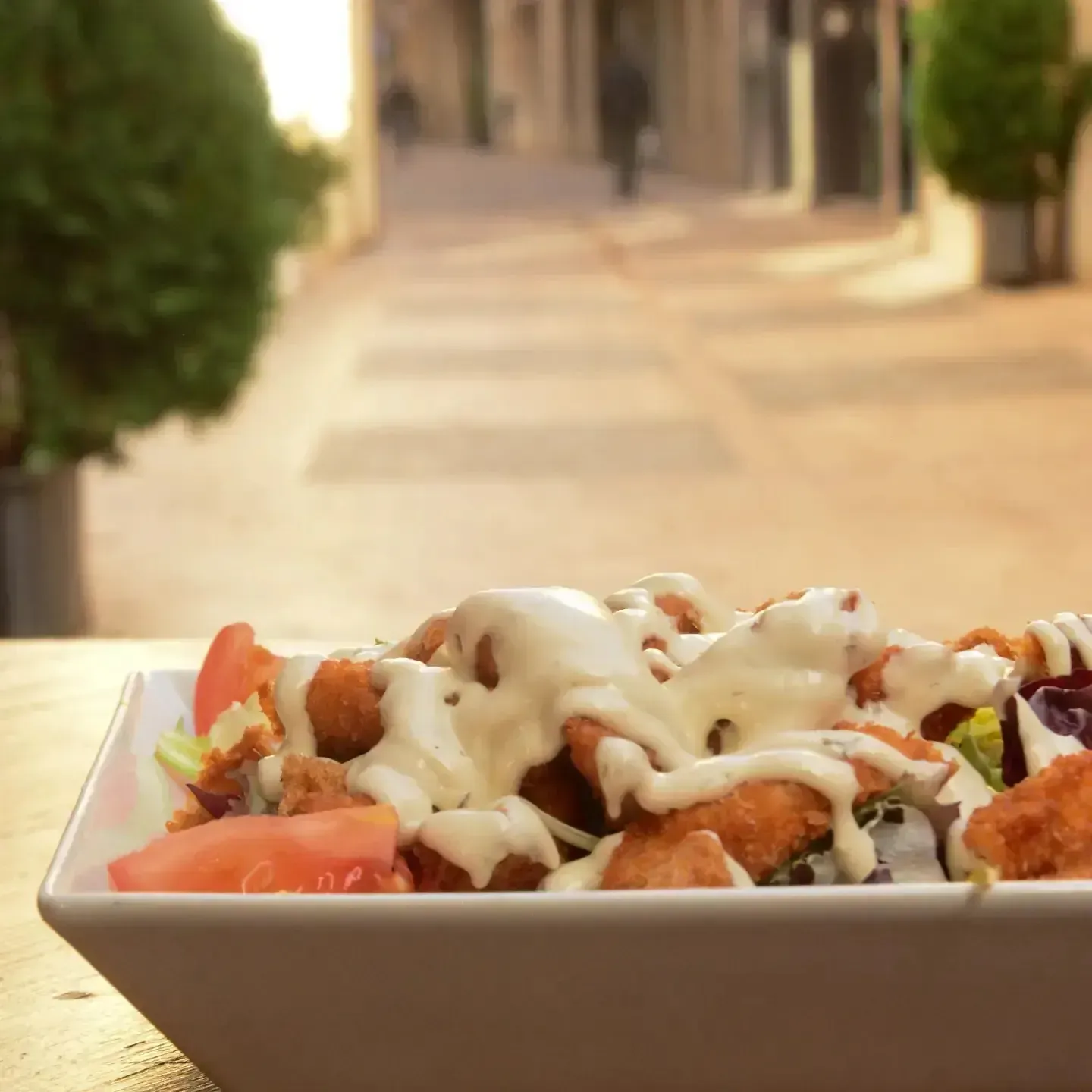 Un tazón de ensalada con pollo y verduras en una mesa.