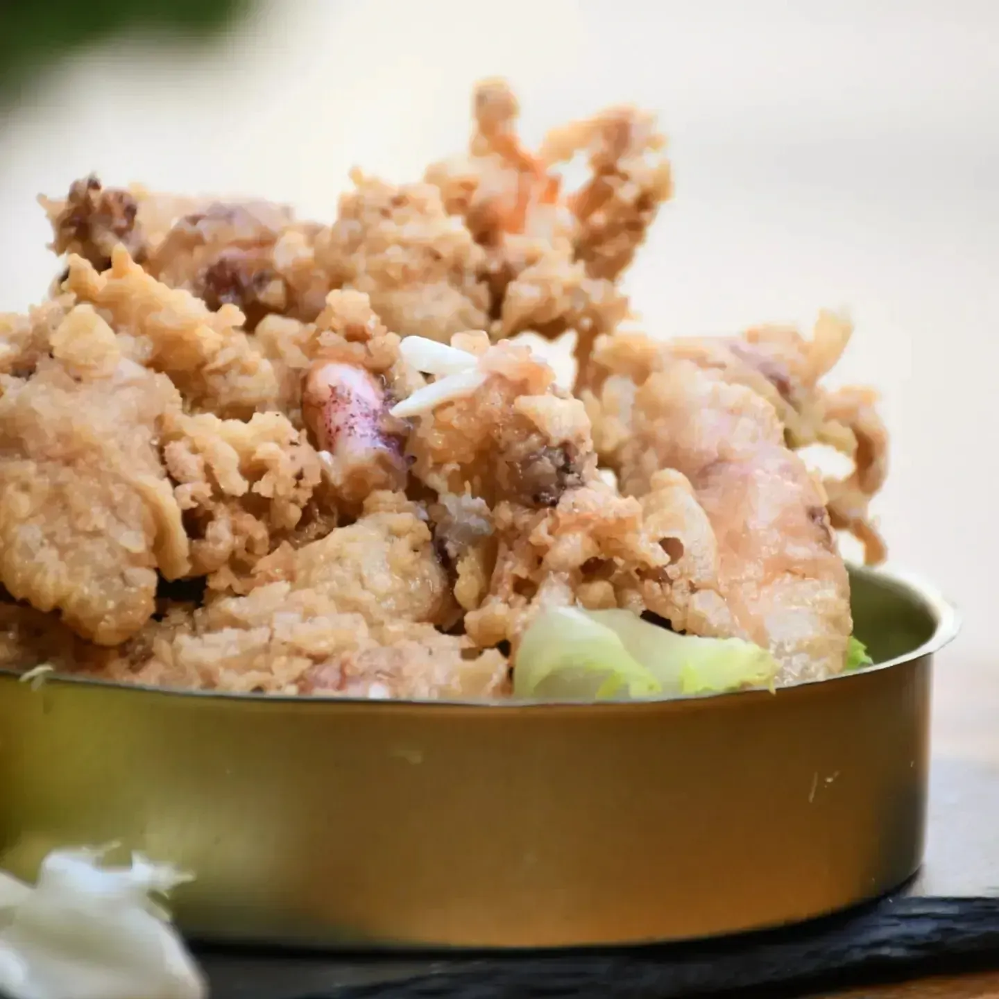 Un recipiente de metal lleno de carne frita y verduras.