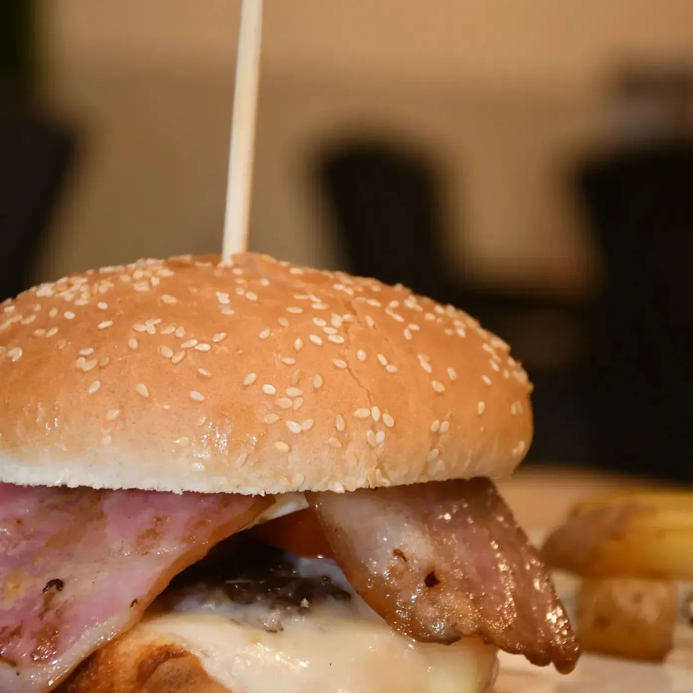 Un primer plano de una hamburguesa con un palillo sobresaliendo de ella.