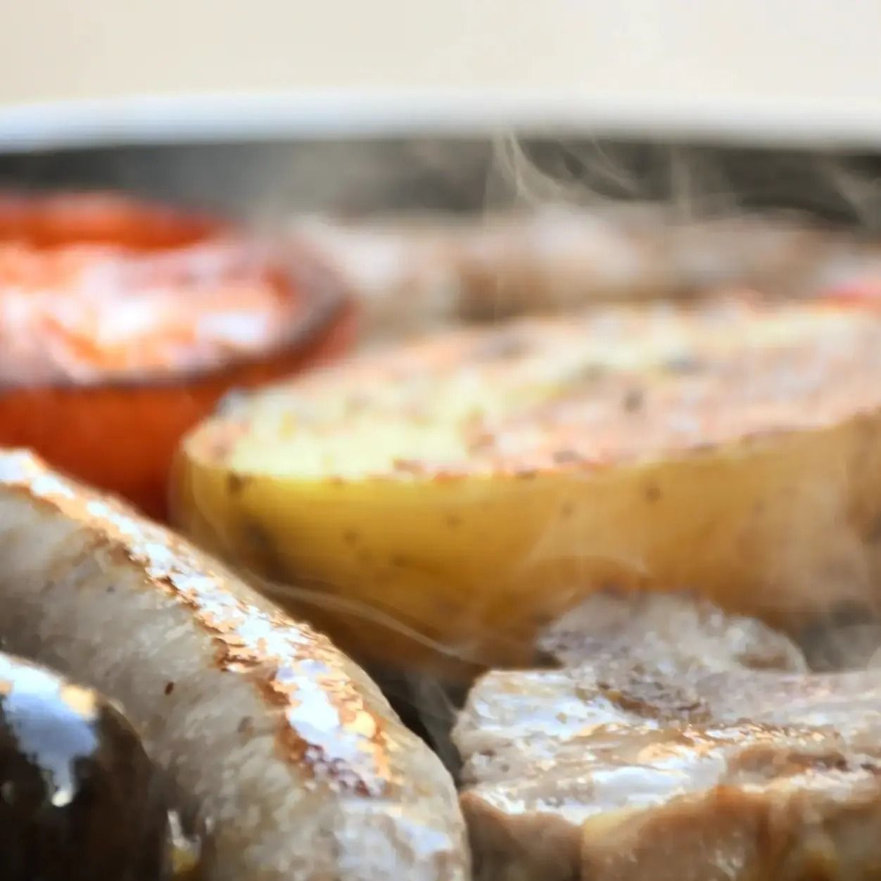 Un primer plano de carne y patatas en una sartén.