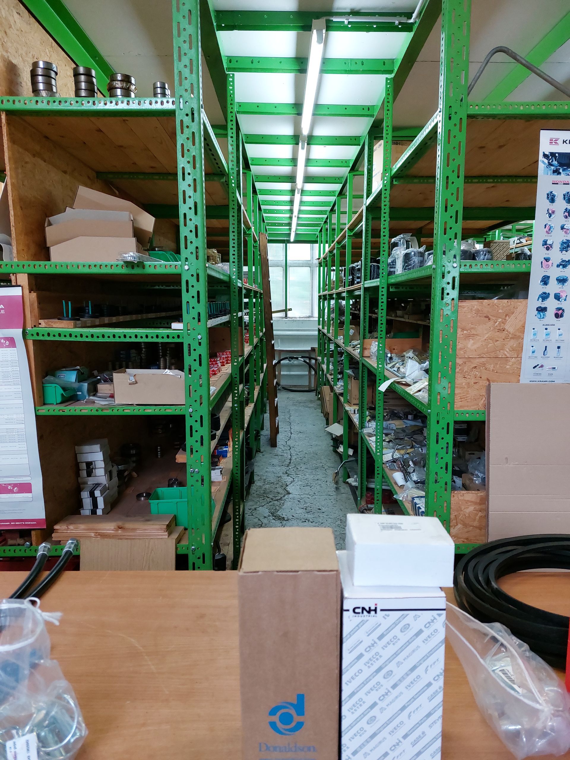 Ein Lagerhaus voller grüner Regale und Kisten.