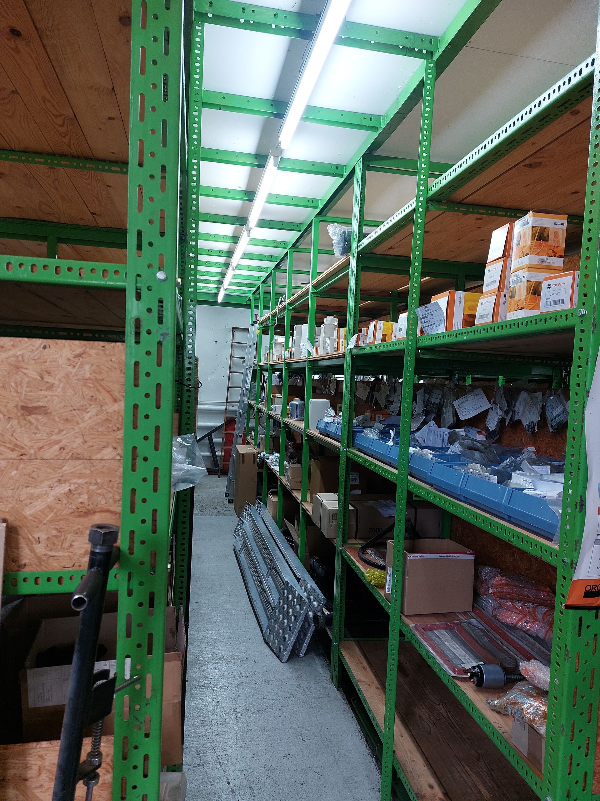 Ein Lager voller grüner Regale und Kisten