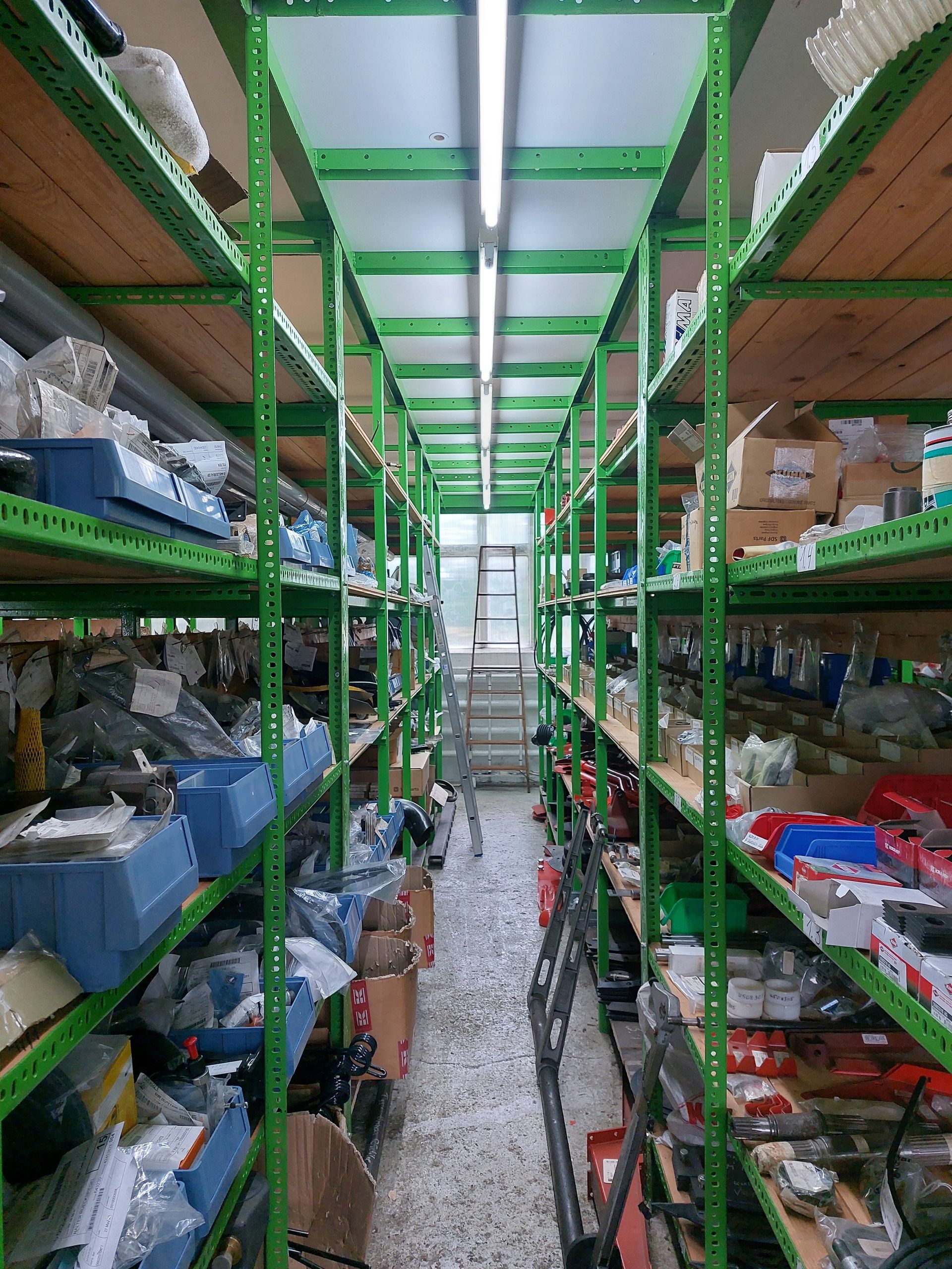 Ein Lager mit vielen grünen Regalen und Kisten