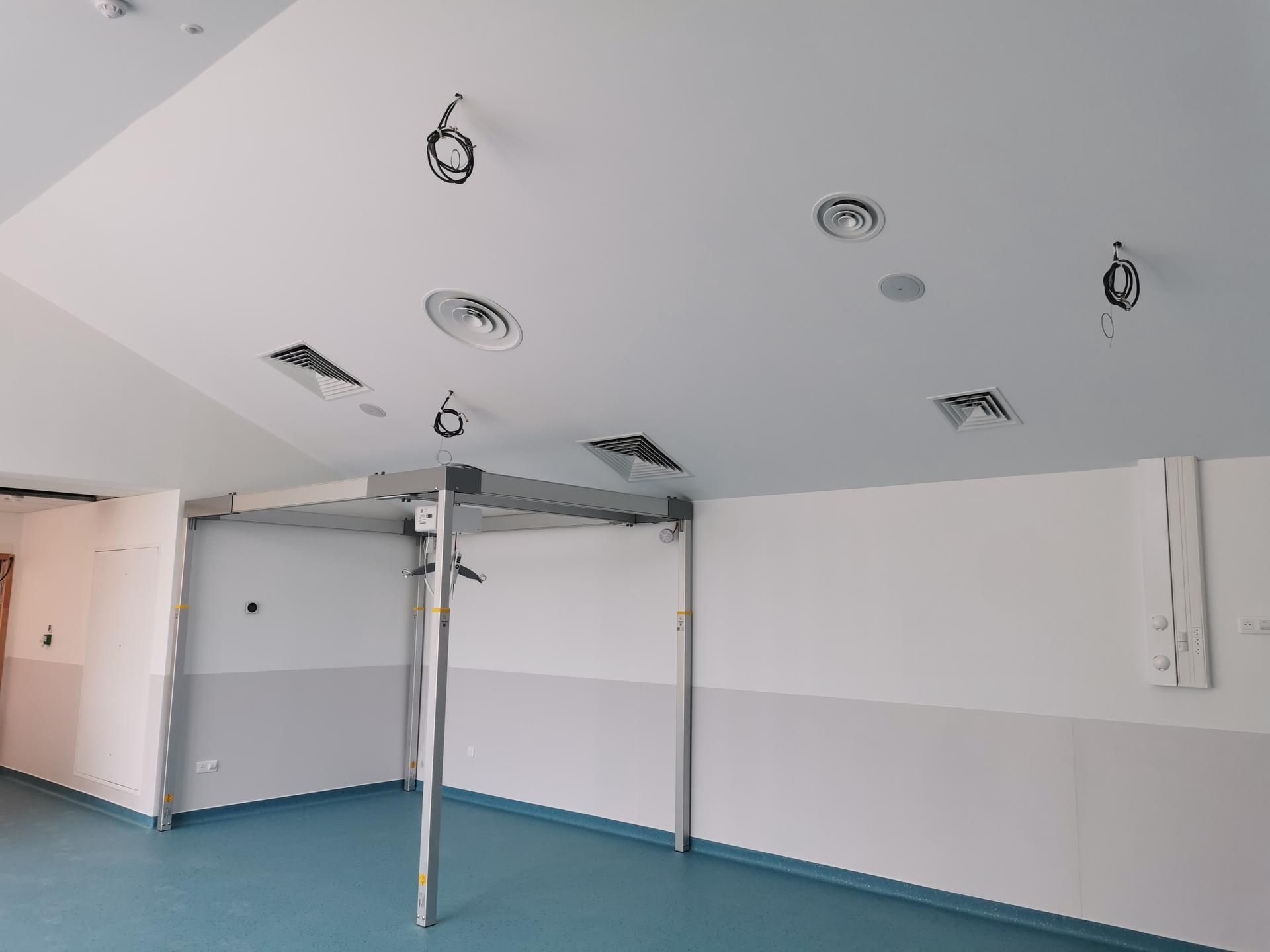 Pièce en cours de rénovation avec des installations électriques et de ventilation au plafond