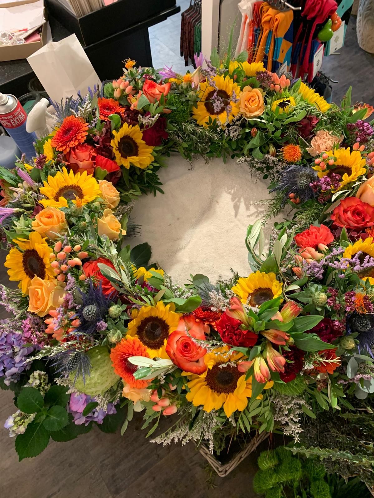 Auf einem Tisch steht ein großer Blumenkranz.