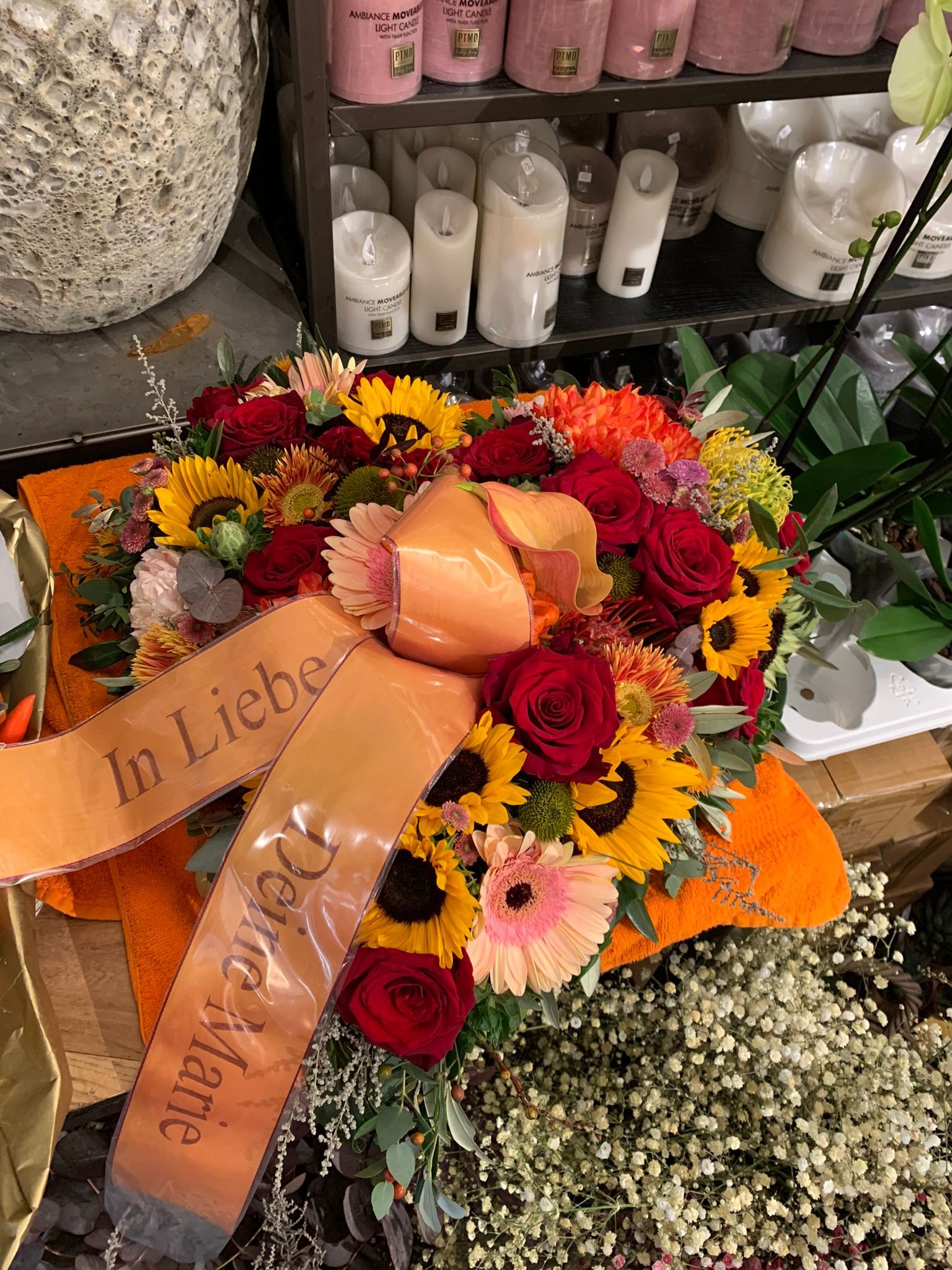 Auf einem Tisch steht ein Blumenstrauß mit einer Schleife darum.