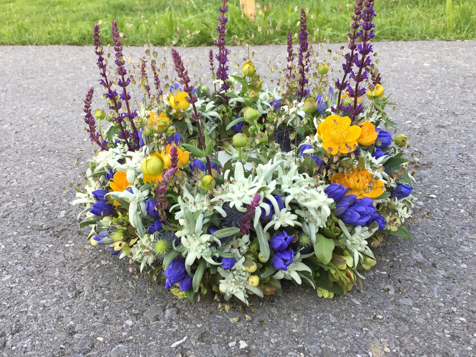 Am Straßenrand liegt ein Blumenkranz.