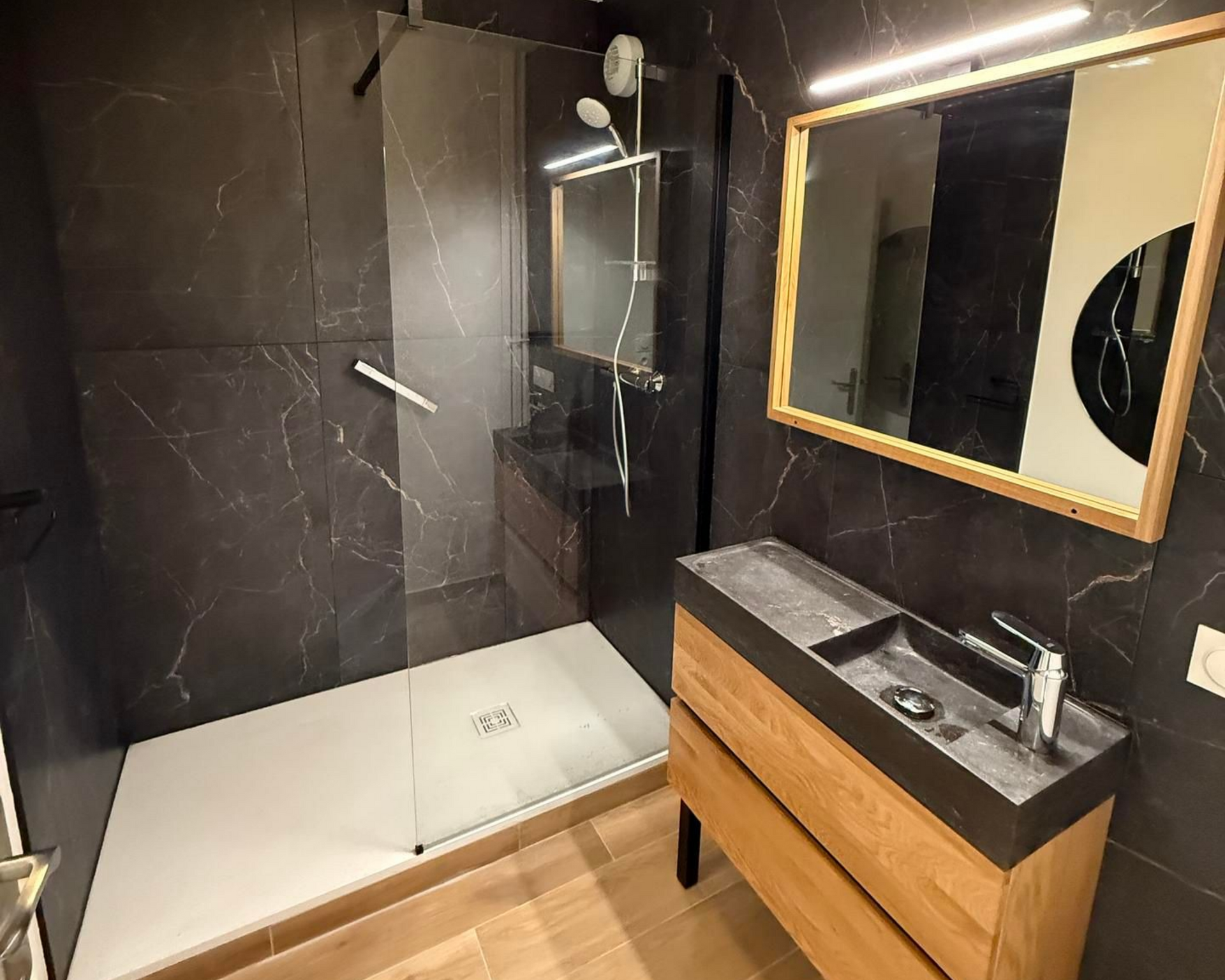 Lavabo blanc avec robinet chromé et distributeur de savon. Placé près d'une fenêtre ornée de plantes vertes.