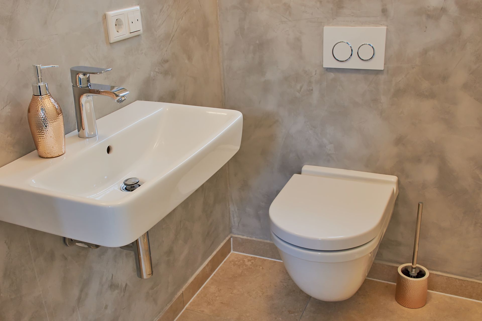 Petite salle de bains moderne avec un lavabo mural, des toilettes et des murs gris décoratifs.