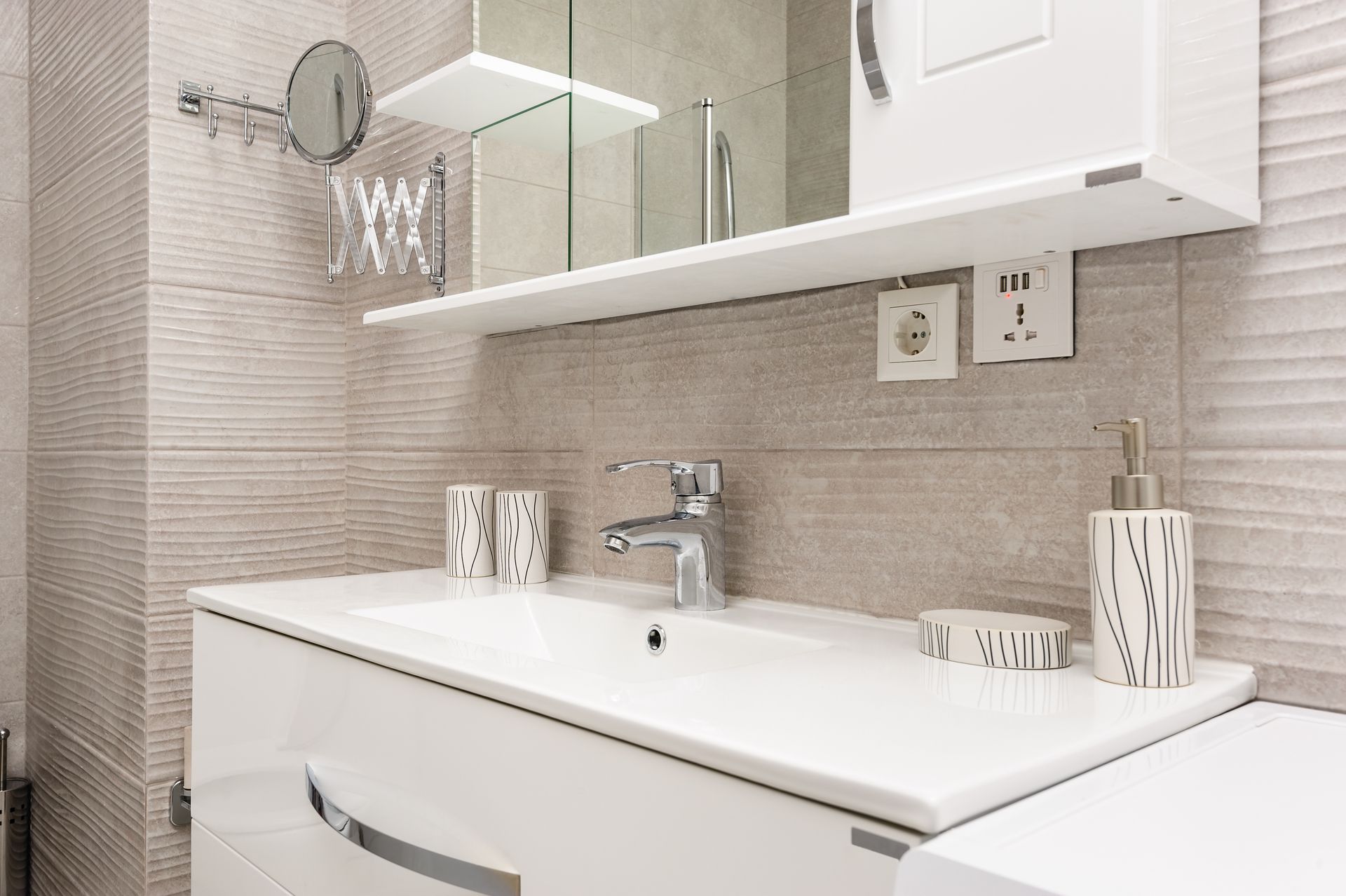 Meuble sous lavabo blanc avecmiroir et accessoires, aux tons neutres et au design moderne.