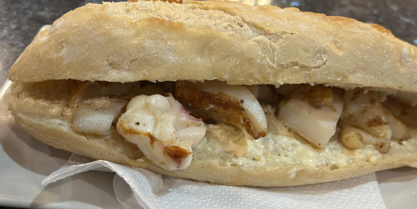 Un primer plano de un sándwich en un plato sobre una servilleta.