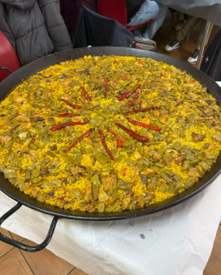 Una olla grande de comida con arroz y verduras sobre una mesa.