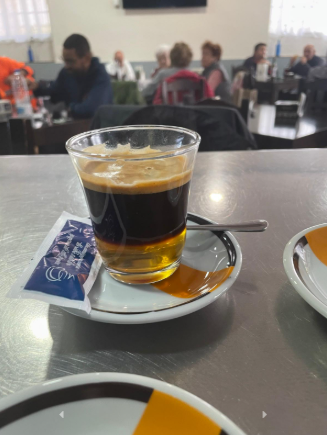 Una taza de café reposa sobre un platillo en una mesa en un restaurante.