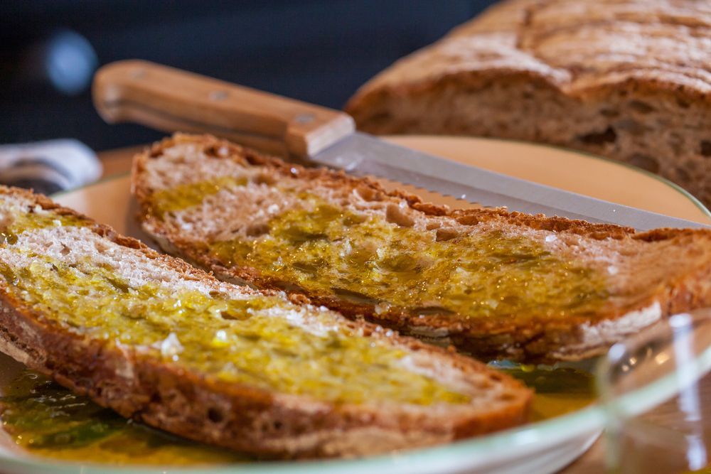 Dos rebanadas de pan están cubiertas con aceite de oliva en un plato.
