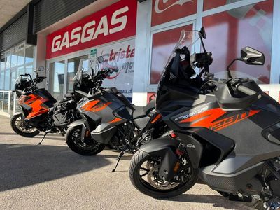 Trois motos KTM garées devant une concession GasGas.