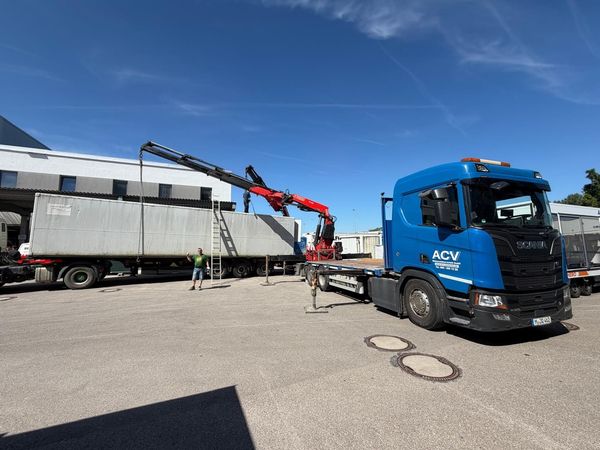 Containerlogistik mit Transportfahrzeug in einer Lager- und Servicehalle