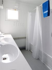 Duschbereich in modernem Sanitärcontainer mit heller und hygienischer Ausstattung Duschbereich in modernem Sanitärcontainer mit heller und hygienischer Ausstattung