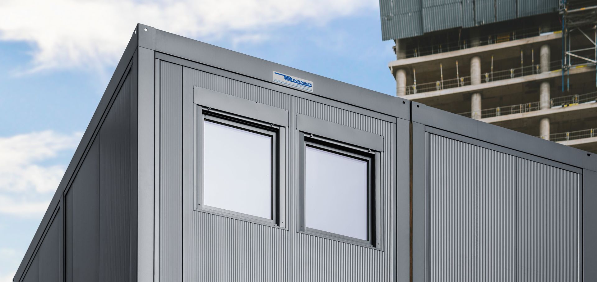 Moderne Containerfassade mit integrierten Fenstern und Sonnenschutzsystemen