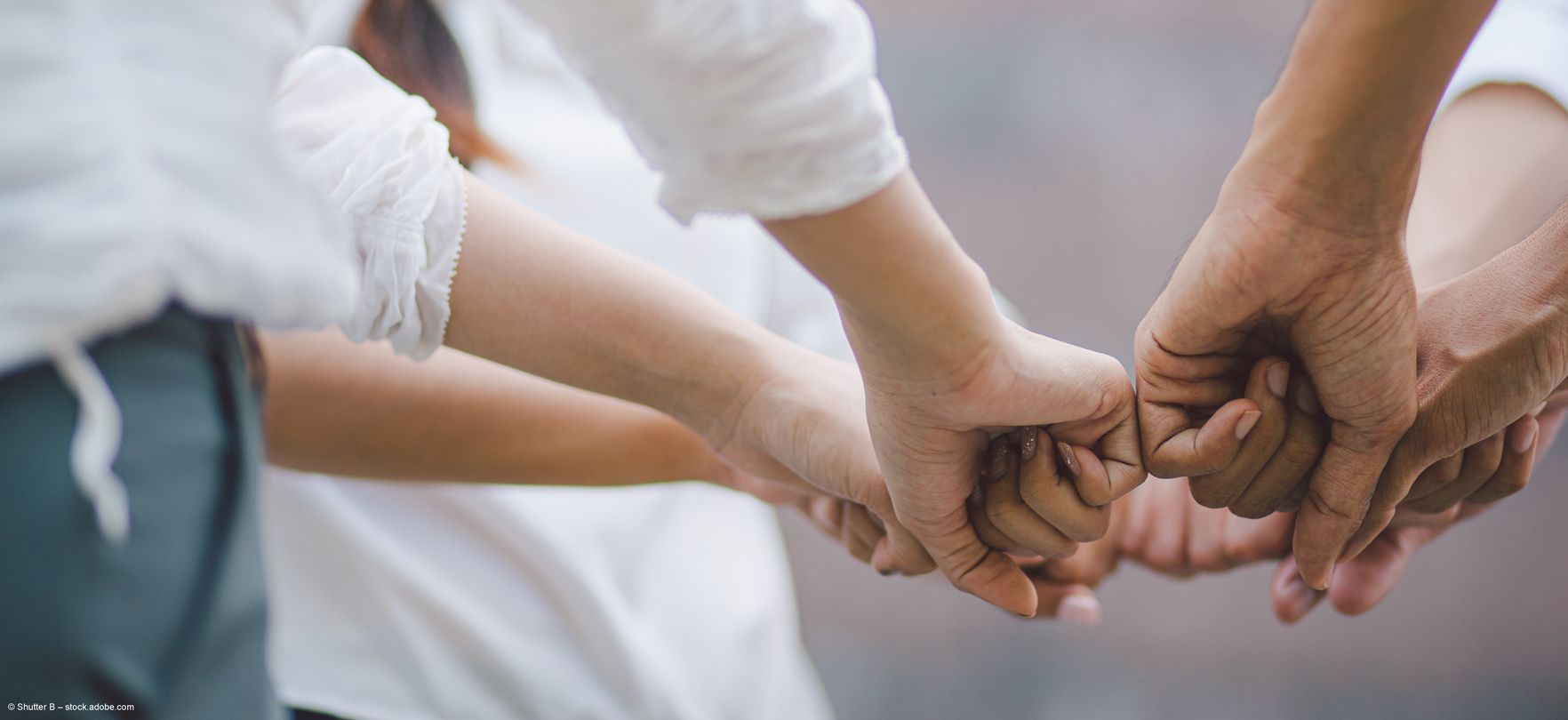 Ein Team von Apothekern steht im Kreis und steckt die Fäuste zusammen