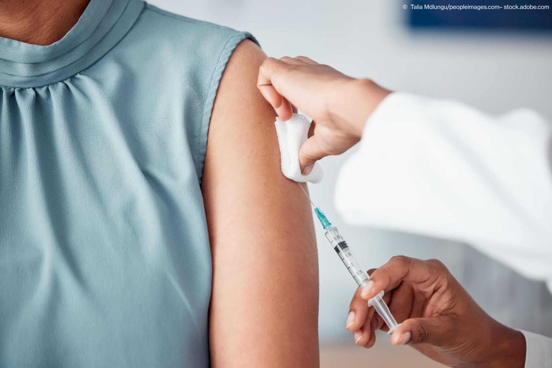 Eine junge Frau erhält eine Impfung in den Oberarm