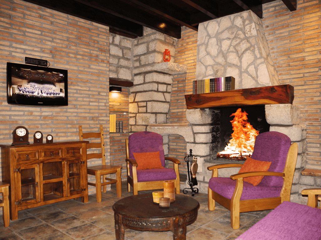 Una sala de estar con sillas moradas y una chimenea.