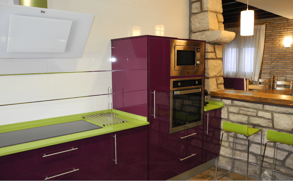 Una cocina con gabinetes morados y encimeras verdes.