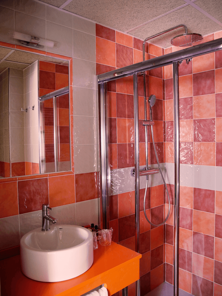 Un baño con lavabo, espejo y ducha.