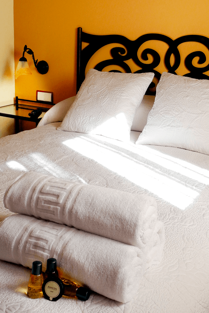 Una cama con toallas blancas y almohadas en una habitación de hotel.