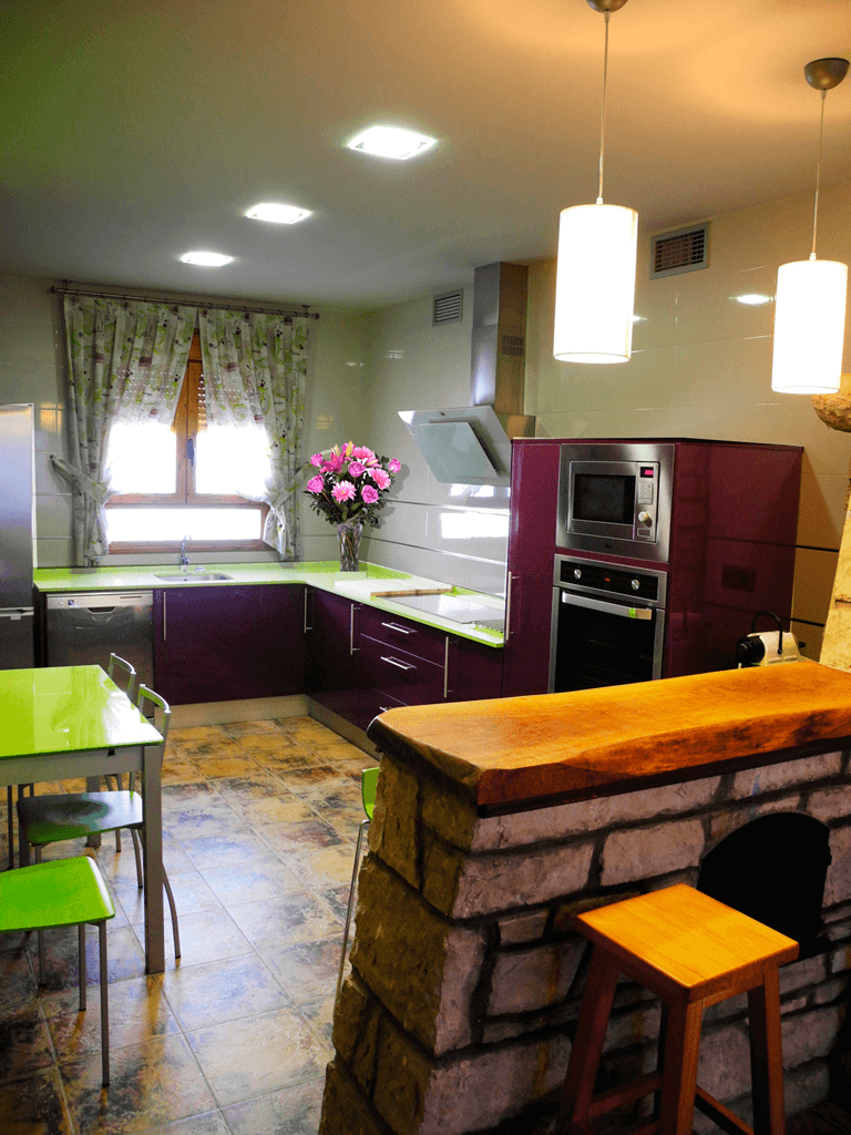 Una cocina con gabinetes morados y encimeras verdes.