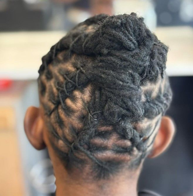 Arrière de la tête avec des dreadlocks savamment coiffées, laissant apparaître des motifs entrecroisés.