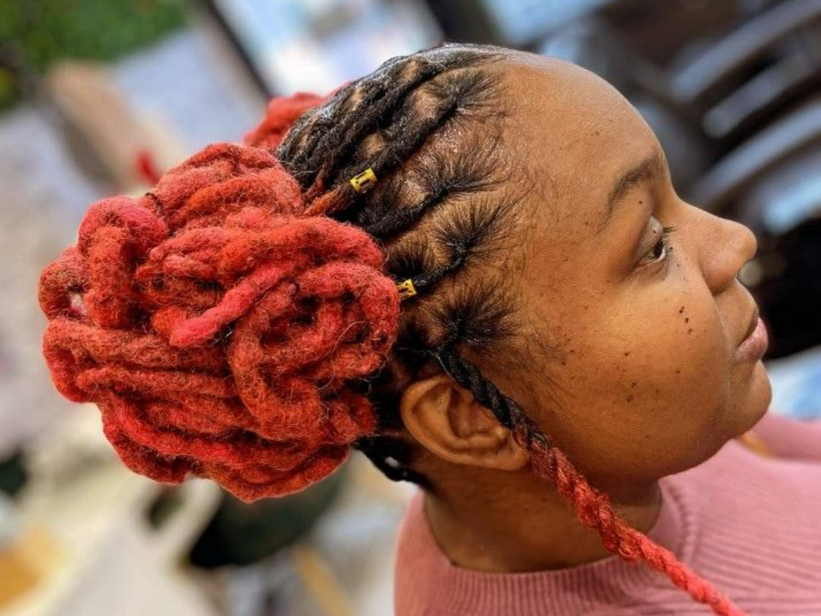 Femme aux dreadlocks rouges et noires coiffées en chignon, tresses le long du cuir chevelu.