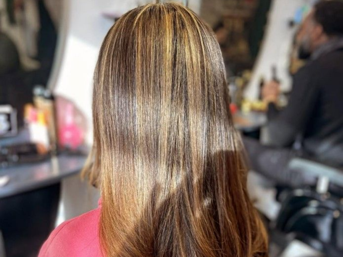 Cheveux avec des mèches blondes, coiffés lisses, à l'intérieur.