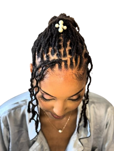 Femme aux cheveux tressés et coiffés en chignon, ornée d'une barrette à perles.