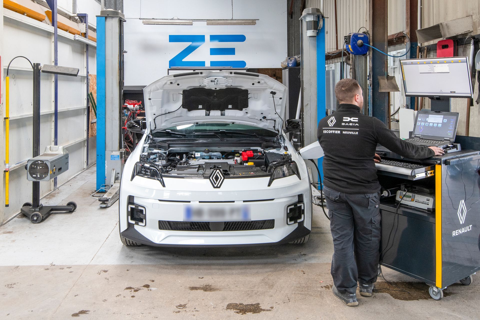 Mécanicien avec une clé à molette au-dessus d'un moteur de voiture 
