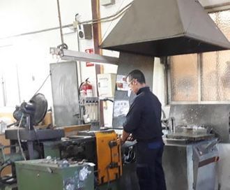Un hombre está trabajando en una máquina en una fábrica.