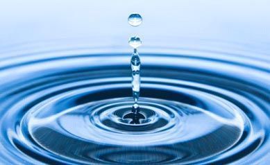 Una gota de agua está cayendo en un charco de agua.