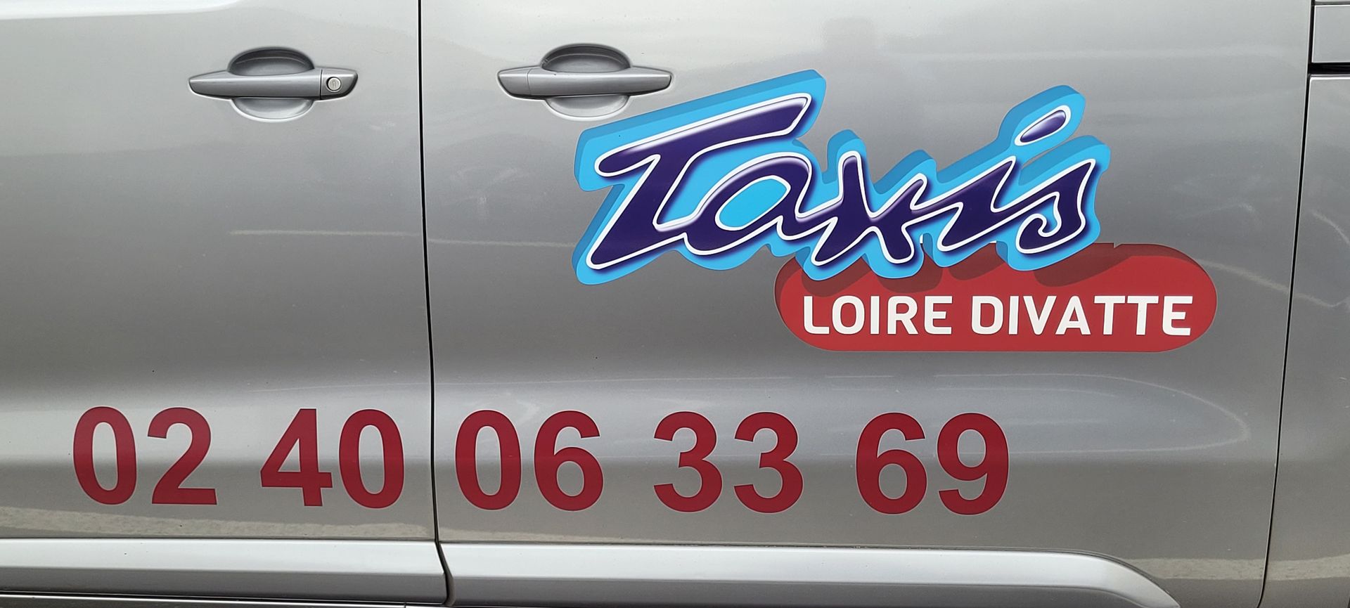 Taxis Bonneau Loire Divatte Signalétique de taxi sur une voiture argentée.
