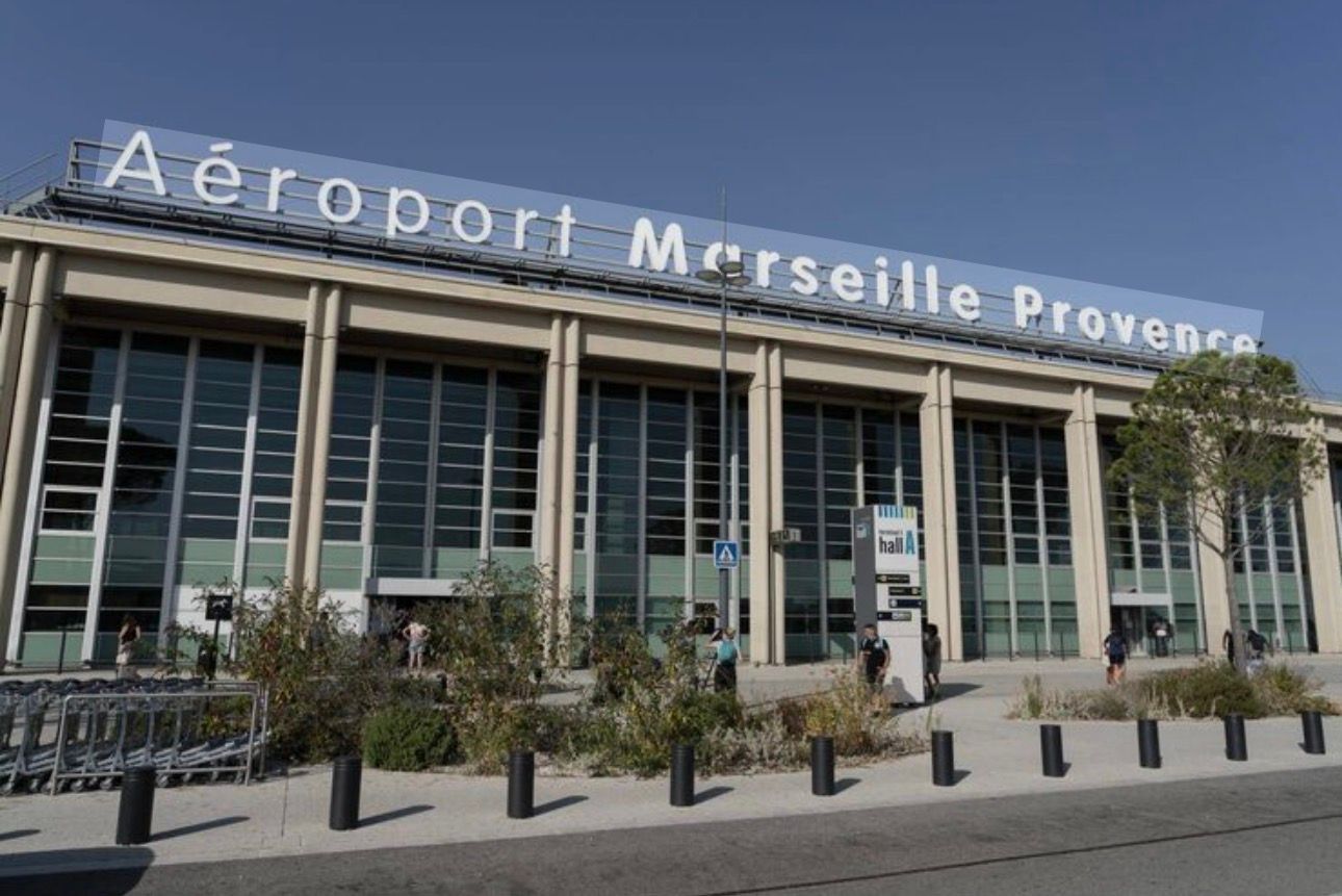 Vue extérieure du terminal de l'aéroport Marseille Provence avec sa signalétique bleue.