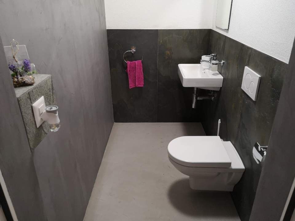 Dunkles Badezimmer in Beton-Optik