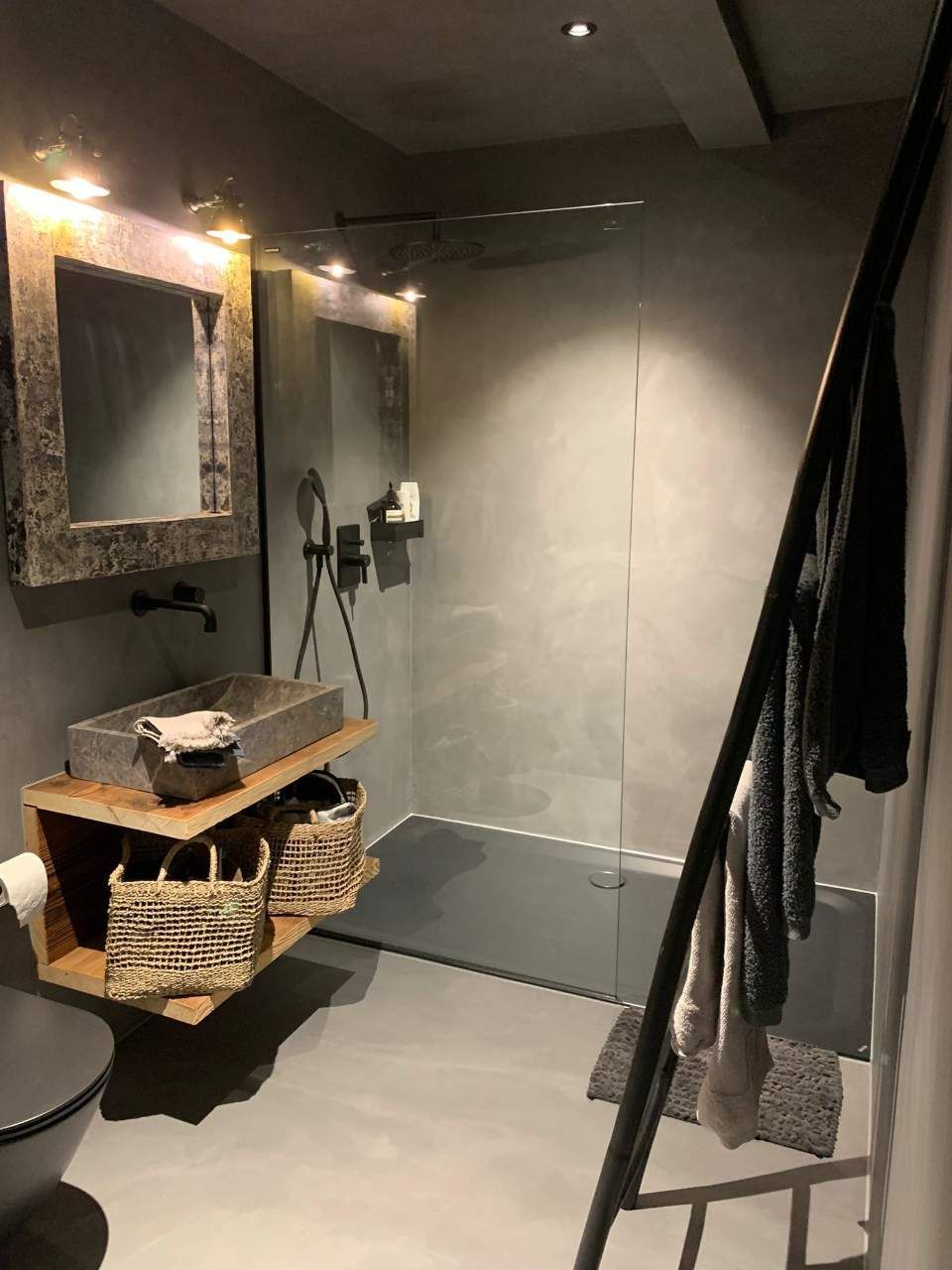 Dunkles Badezimmer mit Betonspachtelboden