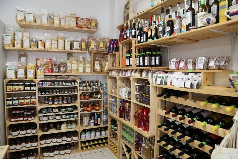 Scaffali di un supermercato pieni di barattoli, bottiglie e prodotti confezionati in una stanza luminosa.