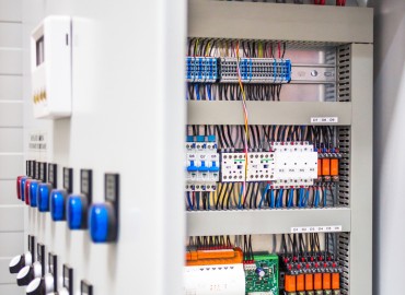 Un gros plan d'un panneau de contrôle électrique avec beaucoup de fils.