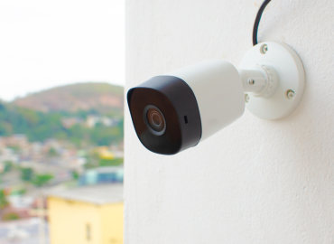 Une caméra de sécurité est montée sur un mur à côté d'une fenêtre.