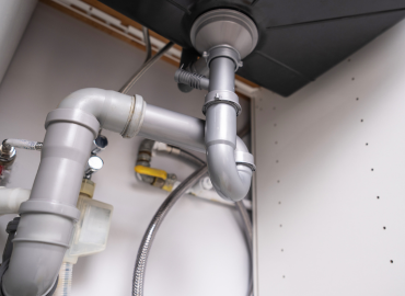 Un gros plan d'un tuyau sous un évier dans une cuisine