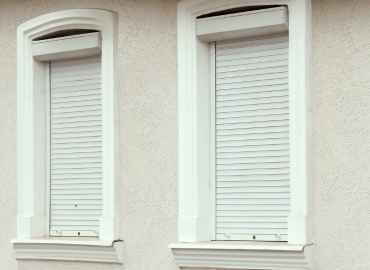 Deux fenêtres avec des volets sur le côté d'un bâtiment