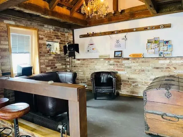 Ein Wohnzimmer mit einer Couch, Stühlen, einer Truhe und einem Kronleuchter.