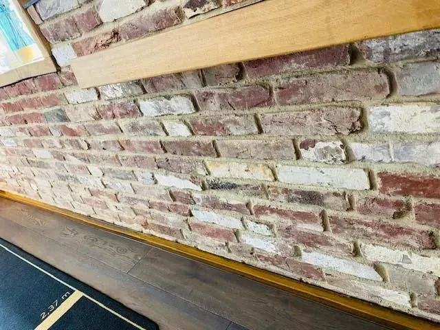 Eine Nahaufnahme einer Ziegelwand mit Holzverkleidung