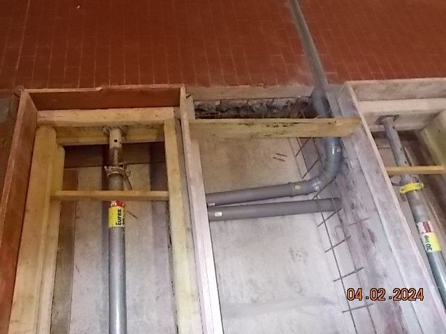 Holzrahmenkonstruktion mit Stützpfeilern und Rohren.